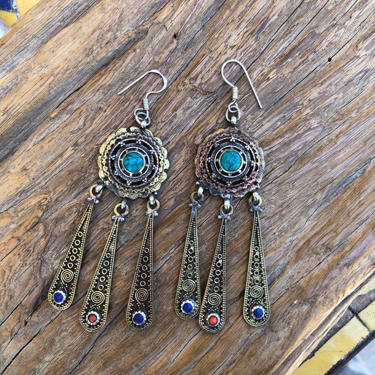 Turquoise and lapis lazuli and corals set on brass earrings Sterling silver ear wire Approximately 4 inches long Artisan Adjustable Drop Earrings Jewelry, Traditional Metal Drop Earrings, Turquoise Metal Earrings, Artisan Turquoise Dangle Jewelry, Nickel Free Brass Dangle Jewelry, Nickel Free Brass Chandelier Earrings For Festivals, Sterling Silver Drop Earrings For Festival, Artisan Jewelry With Natural Stones And Metal, Bohemian Turquoise Dangle Jewelry