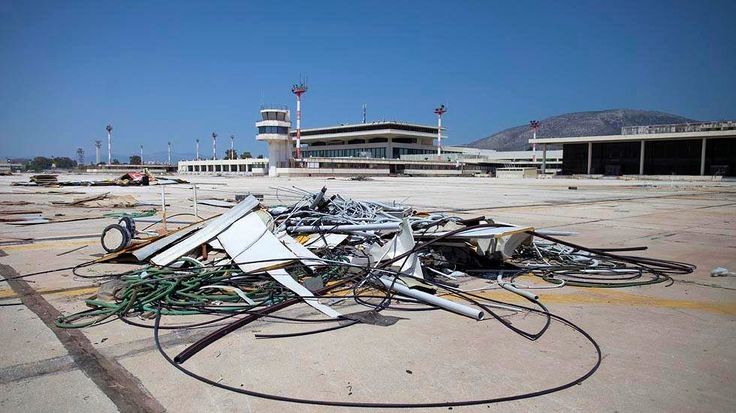 a pile of wires sitting on top of a parking lot next to an airport building