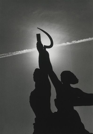 a black and white photo of two people holding an umbrella in front of the sun