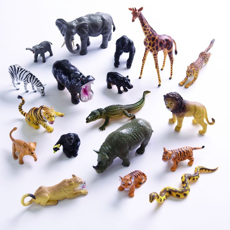 various toy animals are arranged on a white surface