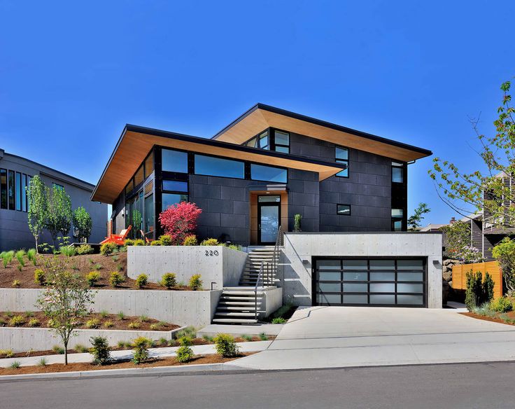 a modern house is shown with stairs leading up to the front door and side entrance