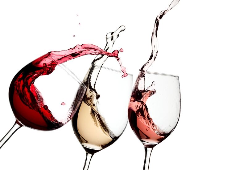 three wine glasses filled with red, white and pink wines splashing into each other