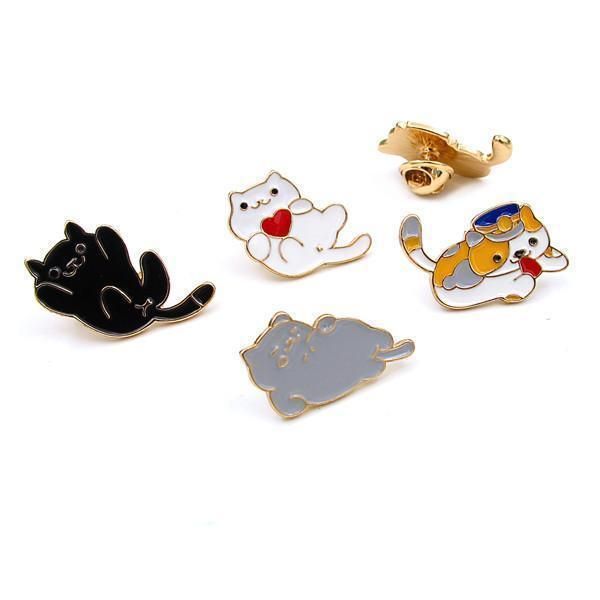 four pins with cats on them sitting next to each other in different shapes and sizes