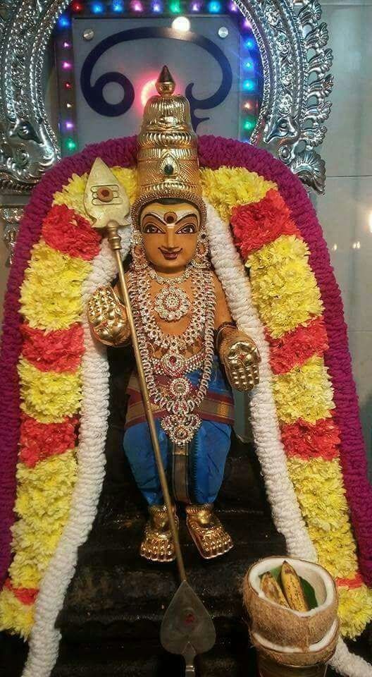 a statue of the hindu god person in front of a decorated stage with lights and decorations