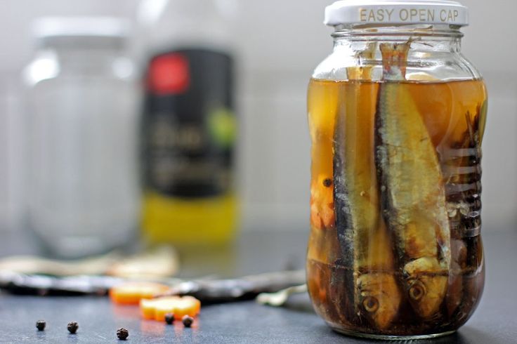 a jar filled with pickles sitting on top of a table next to other bottles