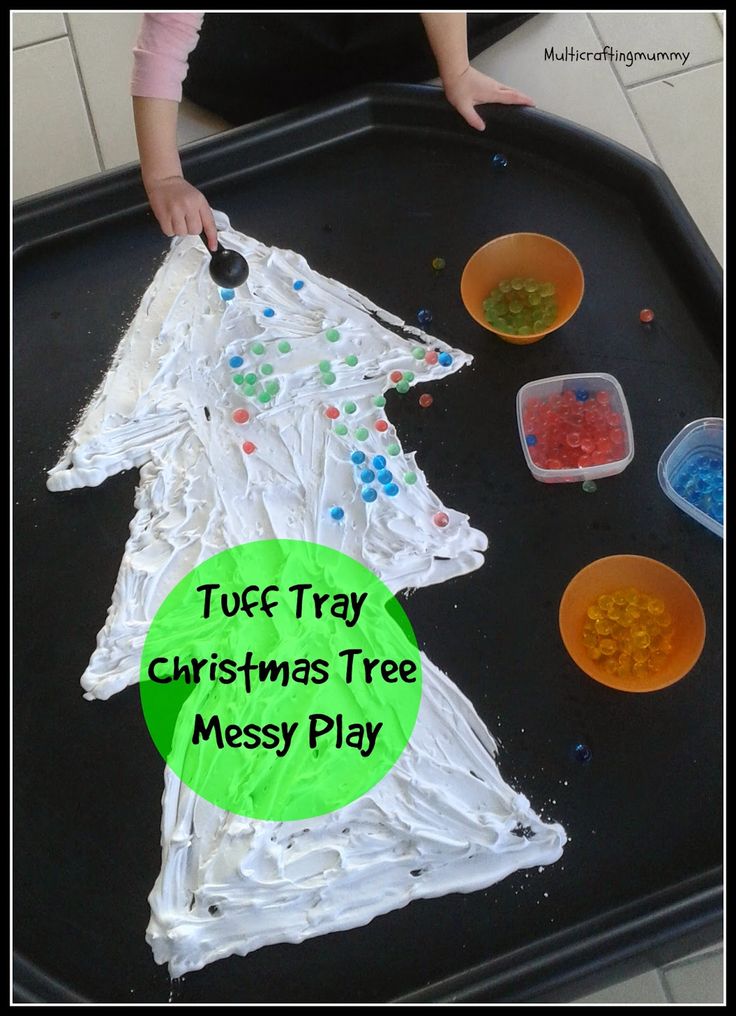 a child is making a christmas tree made out of plastic cups and paper plates on a tray