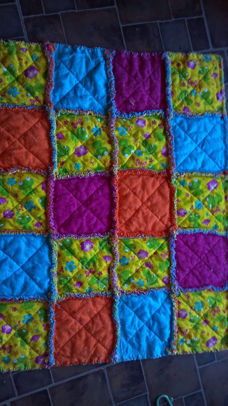 a multicolored patchwork quilt on the floor