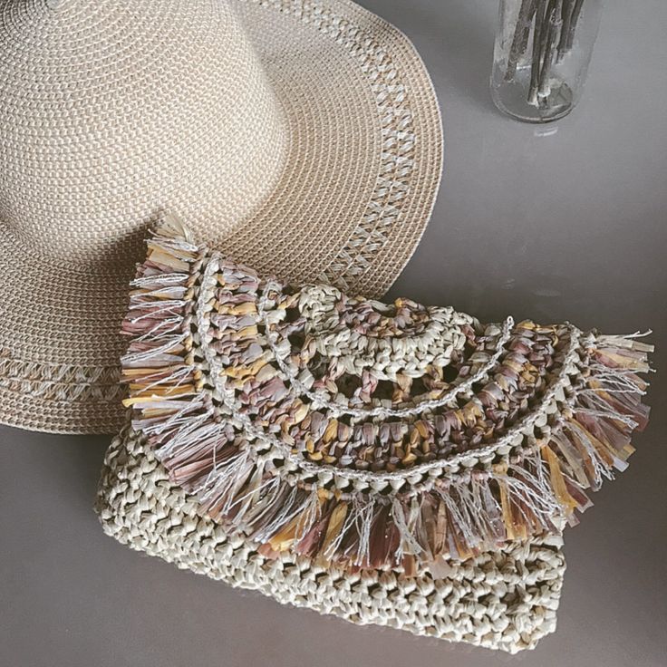 a straw hat and purse sitting on top of a table