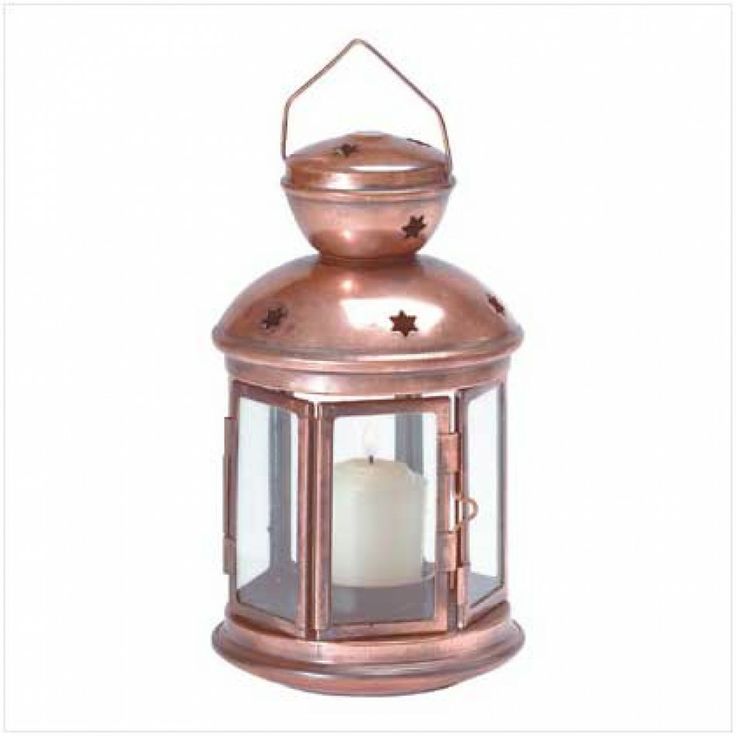 a copper colored lantern with a lit candle inside