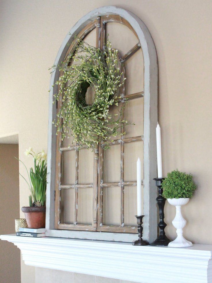 a white mantle with a wreath and candles on it