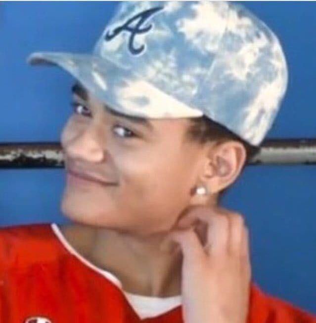 a young boy wearing a baseball cap and smiling