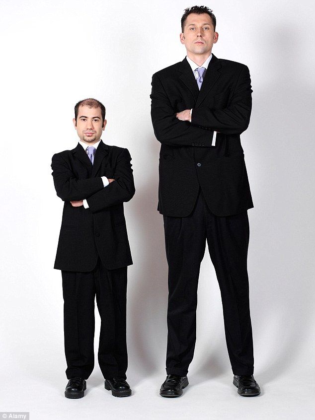 two men in suits standing next to each other with their arms crossed and looking at the camera