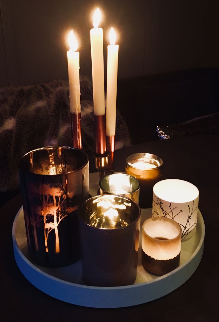 candles are lit on a tray with other items