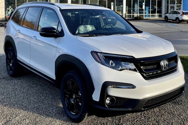 a white honda suv parked in front of a building