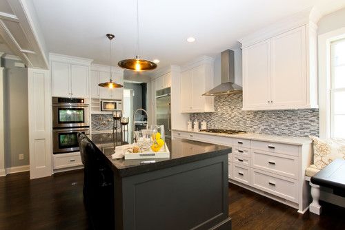 a large kitchen with white cabinets and black counter tops, along with an island in the middle