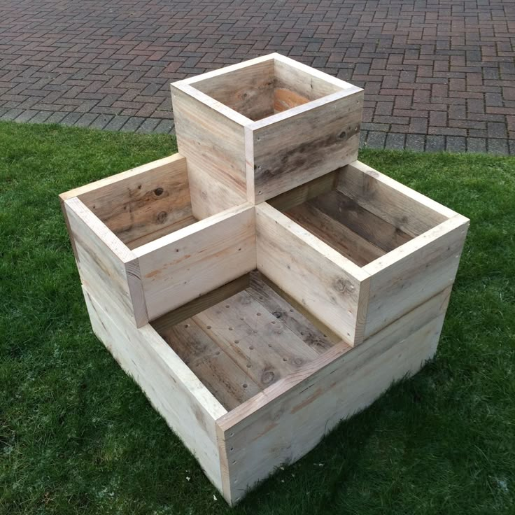 three wooden boxes sitting in the grass