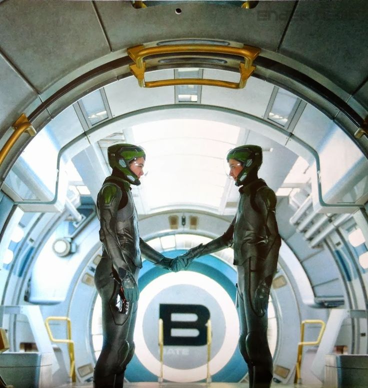 two men in space suits shaking hands with each other on the inside of a spaceship