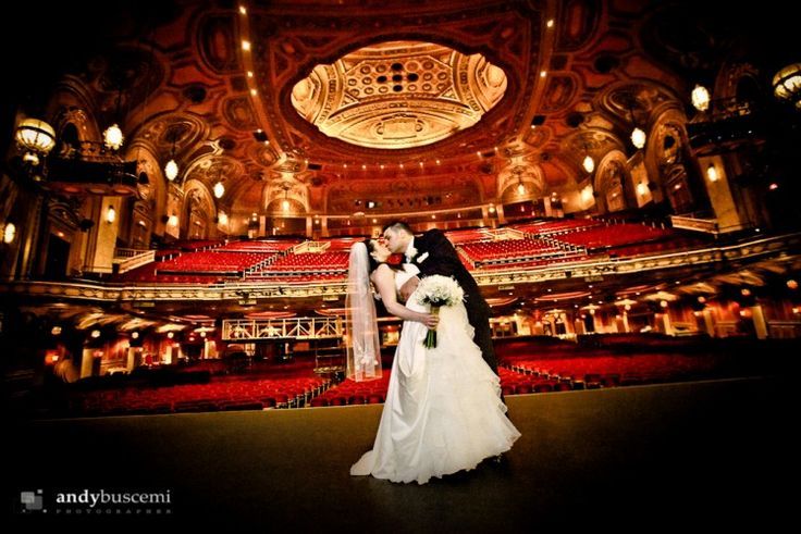 a bride and groom standing in front of an auditorium