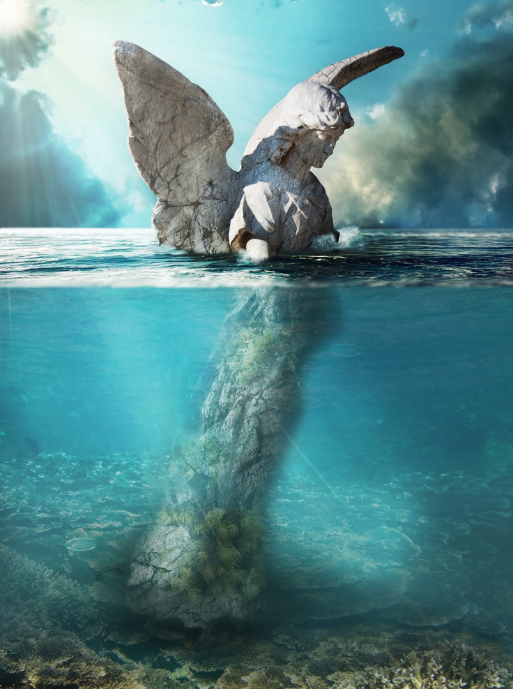 an angel statue floating in the ocean with its wings spread