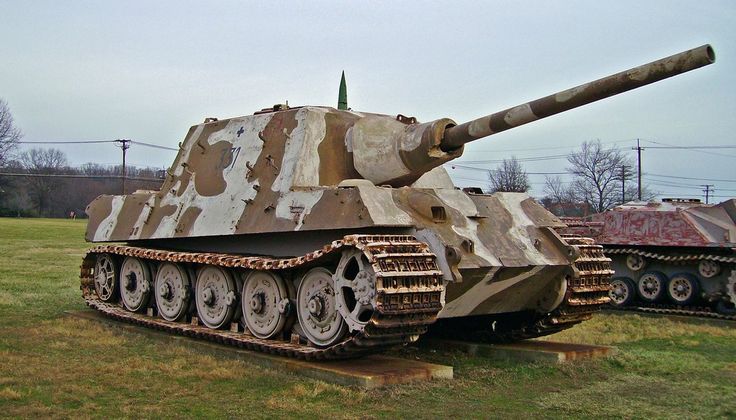 an old tank sitting on top of a field next to other tanks in the grass