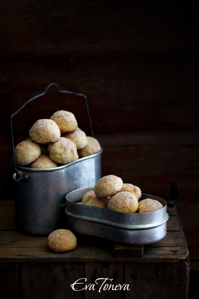 some food is sitting in a metal bowl on a wooden table next to a pot