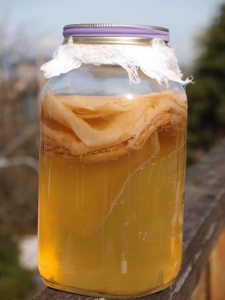 a jar filled with liquid sitting on top of a wooden table