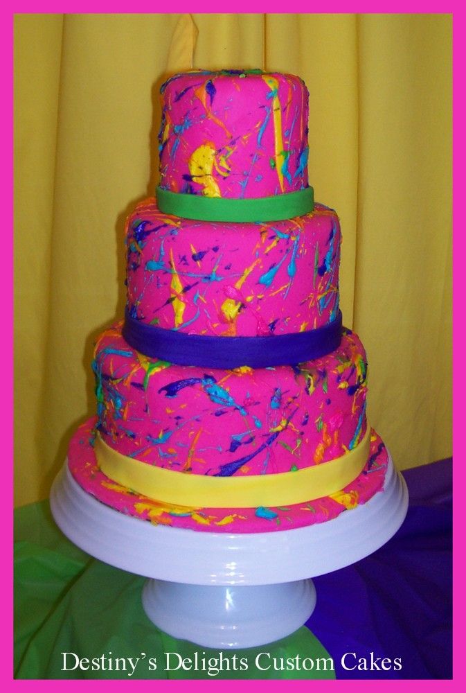 there is a multi layer cake on top of a table with pink and yellow decorations