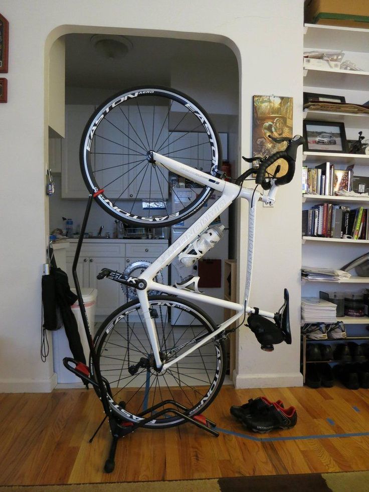 a bicycle is propped up on a bike stand in a room with bookshelves