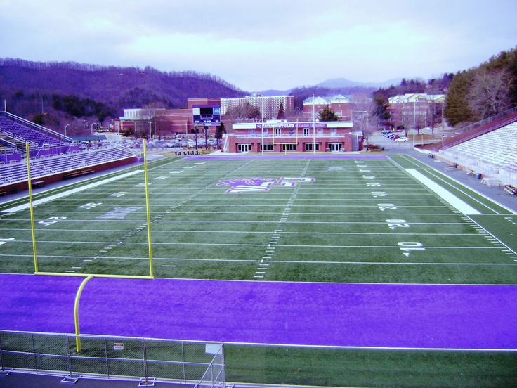 an empty football field with purple paint on it