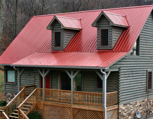 a log cabin with red metal roof and porch