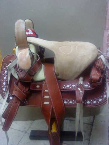 a brown and white horse saddle sitting on top of a tile floor