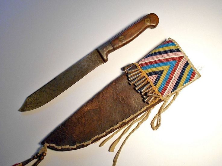 an old knife with a colorful pouch on it