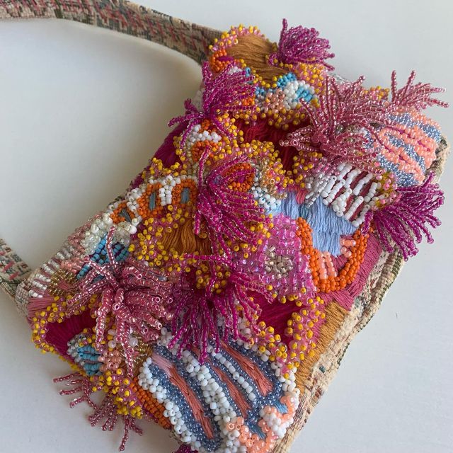 a woven purse with colorful beads on it