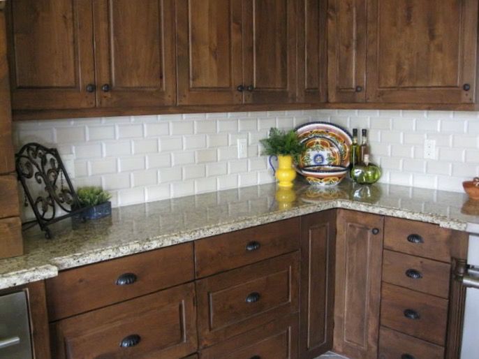 a kitchen with wooden cabinets and white marble counter tops