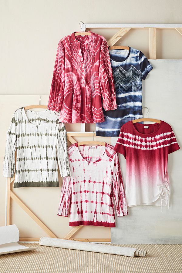 four different colored shirts hanging on a clothes rack