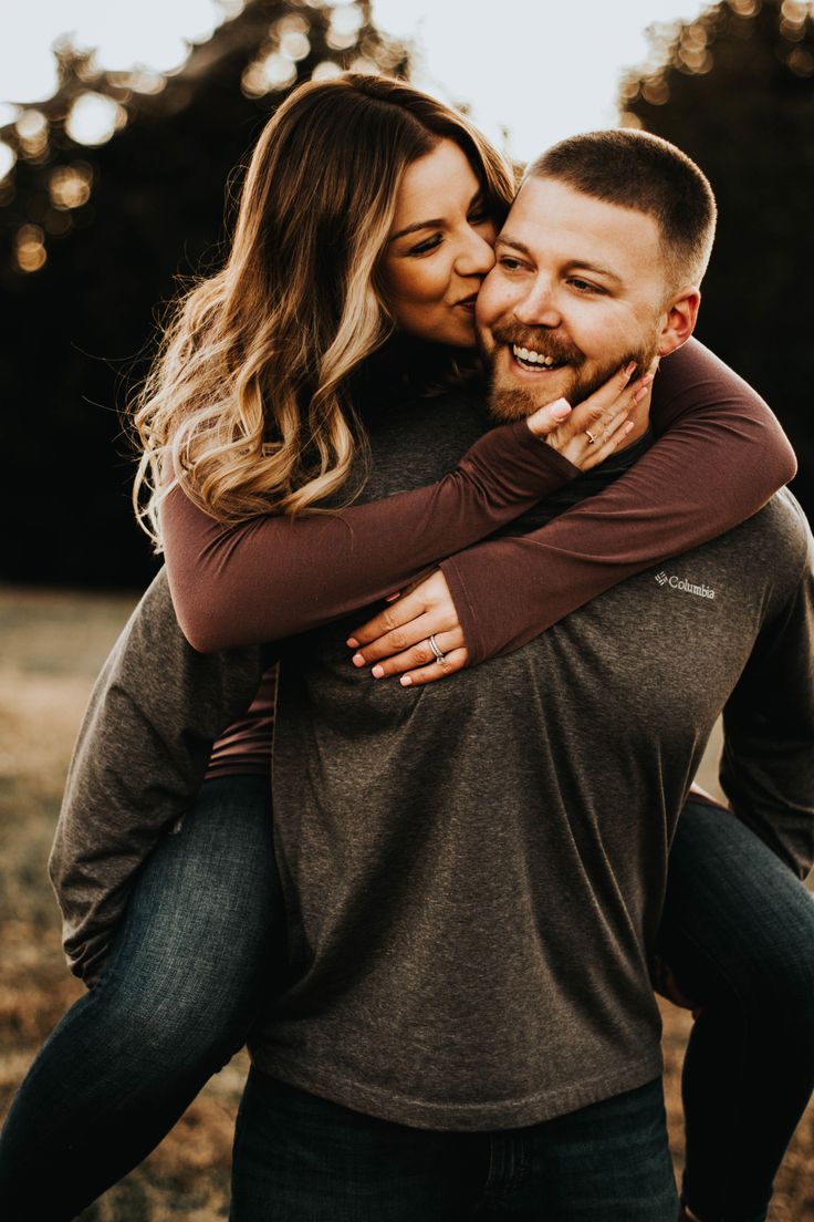 a man and woman hugging each other in an open field