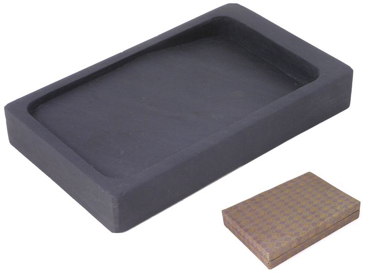 an empty black tray next to a brown box