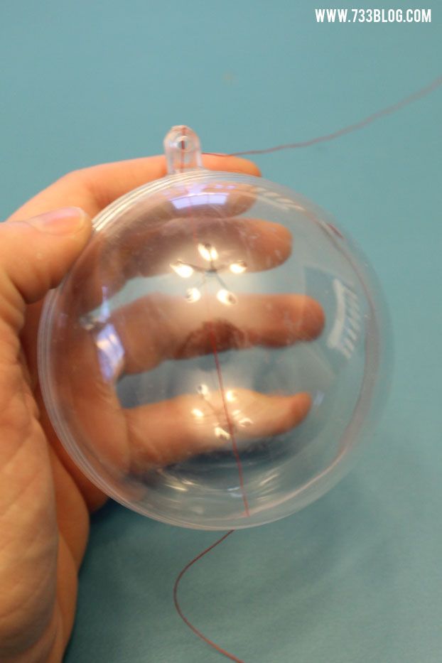 a person holding a clear ball with their hand inside it on a blue table top