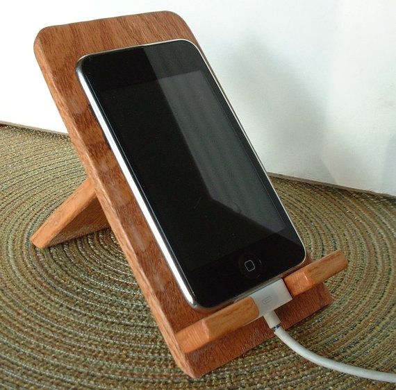 a cell phone is plugged in to a charging station on the carpeted floor