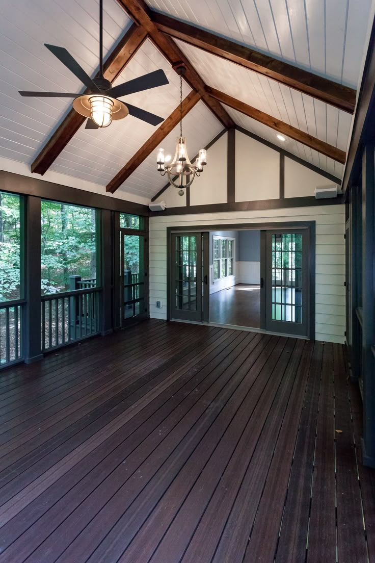 an empty room with wood floors and ceiling fans