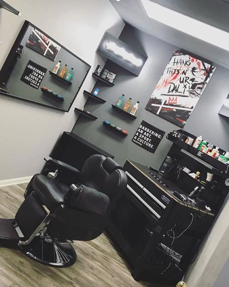 a hair salon with black chairs and pictures on the wall above it, along with other accessories