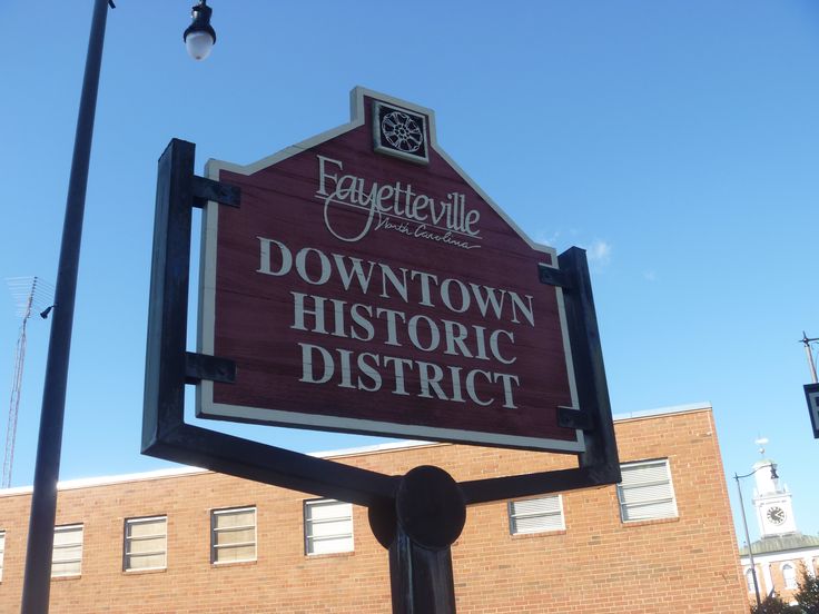 a sign for downtown historic district in front of a brick building