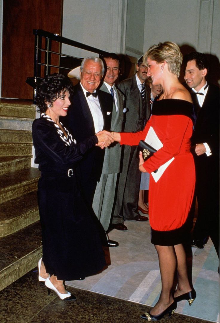 two women shaking hands with men in suits