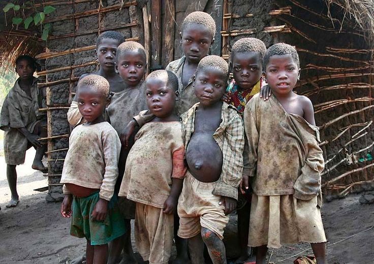 a group of young boys standing next to each other in front of a wooden structure