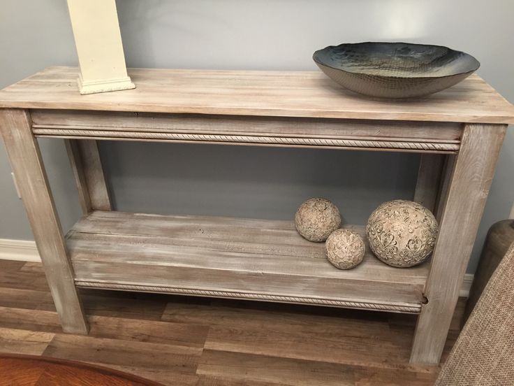 a wooden table with three balls on it and a bowl sitting on top of it