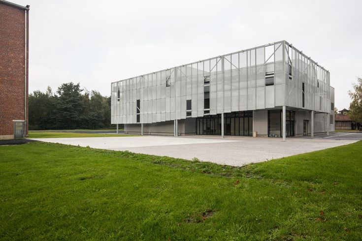 an empty parking lot in front of a building with large windows on the top floor