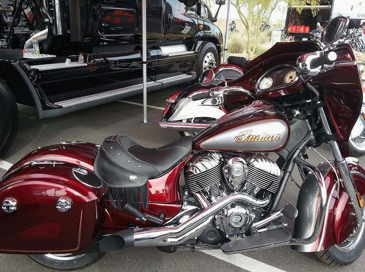 two motorcycles parked next to each other in front of a black truck and another vehicle