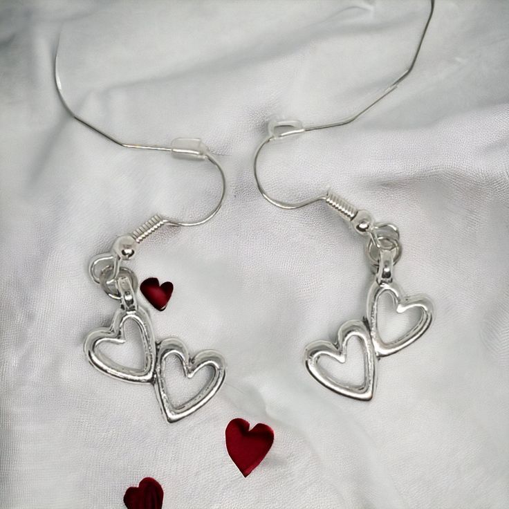 Our enchanting double heart Earrings - a whimsical blend of elegance and charm designed for special occasions such as birthdays, Valentine's Day, Mother's Day, or any moment you want to make unforgettable. Crafted with meticulous attention to detail, these earrings are designed to captivate with 2 hollow hearts pendant suspended from French wire hooks. The hooks, plated with 14k white gold, ensure both style and hypoallergenic comfort for all-day wear. The double heart pendant, made from silver- Birthday Jewelry With Dangling Charms, Heart Charm Dangle Jewelry For Anniversary, Anniversary Heart Charm Dangle Jewelry, Anniversary Dangle Jewelry With Heart Charm, Hypoallergenic Heart-shaped Jewelry For Valentine's Day, Valentine's Day Open Heart Metal Jewelry, Heart-shaped Dangling Charms Jewelry For Valentine's Day, Dangling Charms Jewelry For Valentine's Anniversary, Heart Charm Dangle Jewelry For Gifts