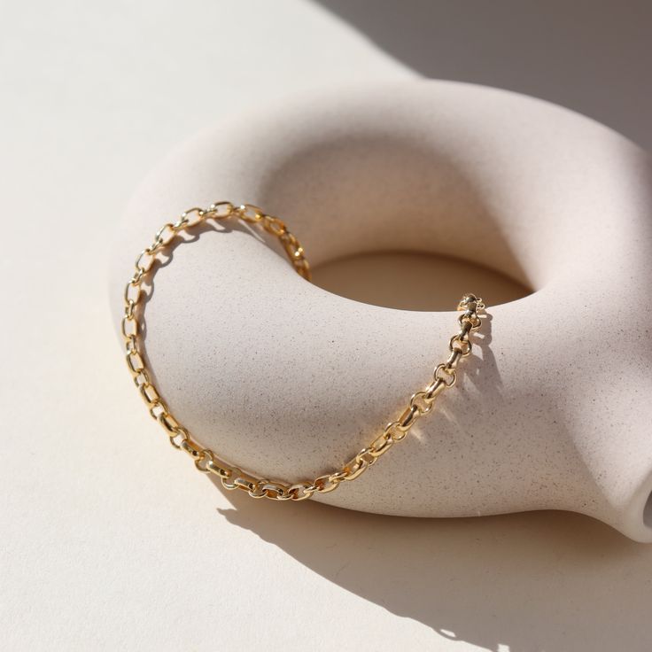 Picture a sleek and elegant gold bracelet, designed with minimalism in mind. It features a delicate chain crafted from shimmering 14k gold fill, offering a subtle yet luxurious glow. This piece embodies sophistication and refinement, perfect for adding a touch of timeless elegance to any ensemble. DETAILS14k gold fill Hypoallergenic, water proof, and nickel free To determine your wrist size, use a tape measure or ribbon around your wrist, then measure against a ruler. Dainty 14k Gold Filled Adjustable Chain Bracelet, Modern Everyday 14k Gold Filled Bracelet, Minimalist Tarnish Resistant Recycled Gold Bracelet, Minimalist 14k Gold Filled Bracelet With Adjustable Chain, Dainty Yellow Gold Bracelets Made From Recycled Gold, Elegant Gold Bracelet With Oval Link Delicate Chain, Elegant Gold Bracelet With Delicate Oval Link Chain, Delicate Yellow Gold Oval Link Chain Bracelet, Dainty Gold Bracelet With Adjustable Chain For Everyday