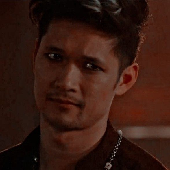 a young man with dark hair and piercings looks at the camera while wearing a leather jacket